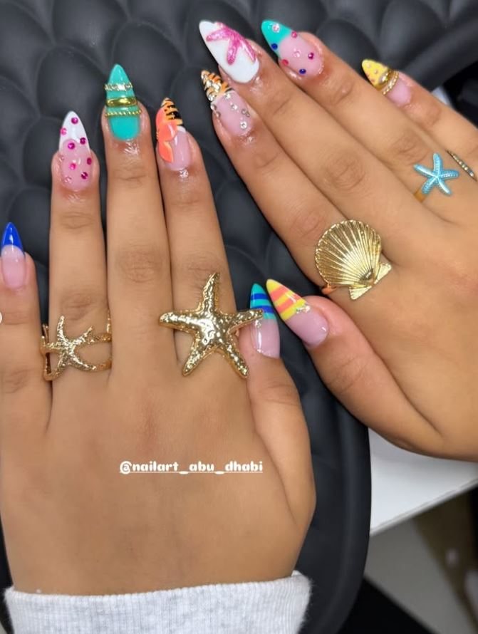 Long stiletto nails painted with starfish, shells and pastel summer designs